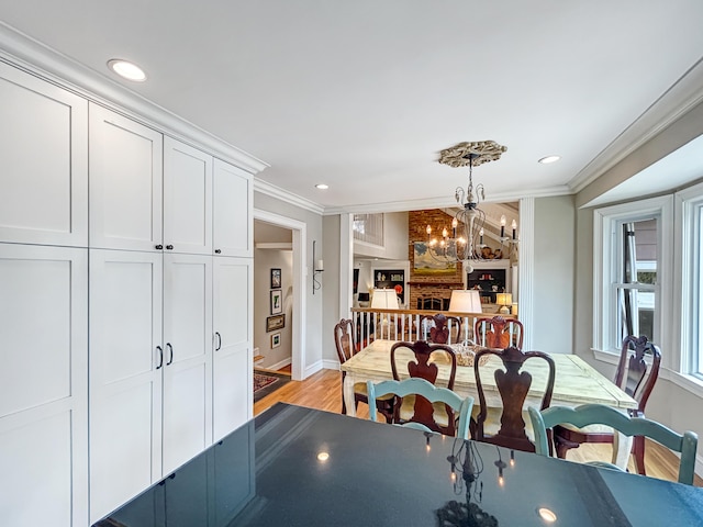 dining space with light wood-type flooring, recessed lighting, an inviting chandelier, and crown molding