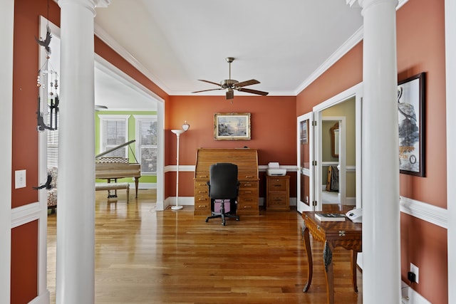 office area featuring ceiling fan, crown molding, decorative columns, and wood-type flooring