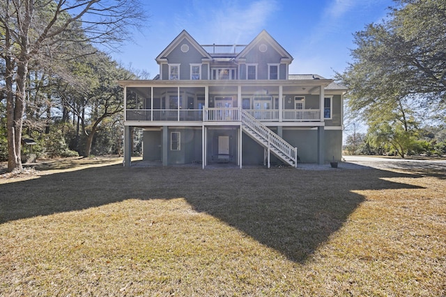 rear view of house with a lawn, a sunroom, and covered porch