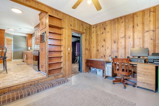 home office with ceiling fan and wooden walls