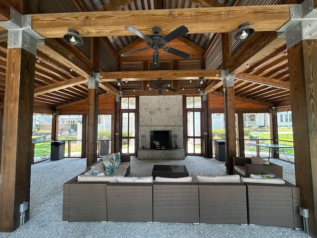 unfurnished living room with high vaulted ceiling, a large fireplace, beam ceiling, and ceiling fan