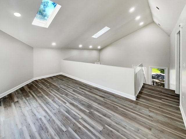 bonus room featuring high vaulted ceiling, a skylight, and hardwood / wood-style floors