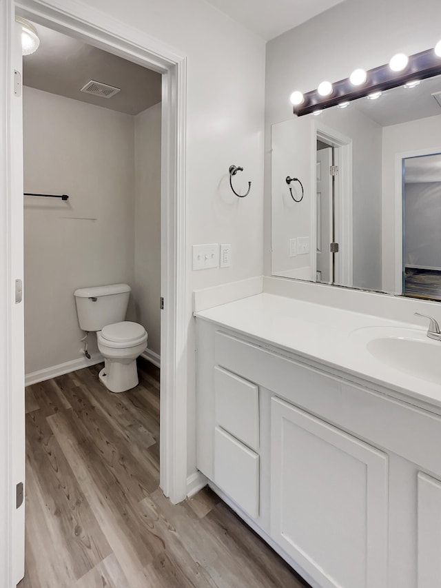 bathroom with vanity, toilet, and wood-type flooring