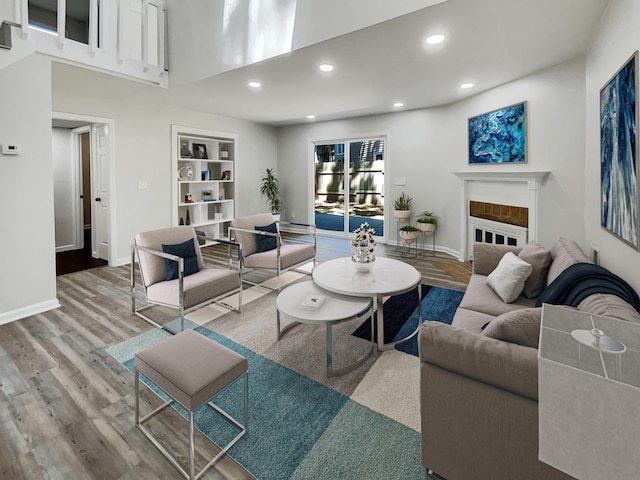 living room with light wood-type flooring and a towering ceiling