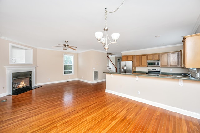 2301 N Creek Dr, Mount Pleasant, SC 29466 - kitchen featuring appliances with stainless steel finishes, light wood-style flooring, ceiling fan, a chandelier, and ornamental molding