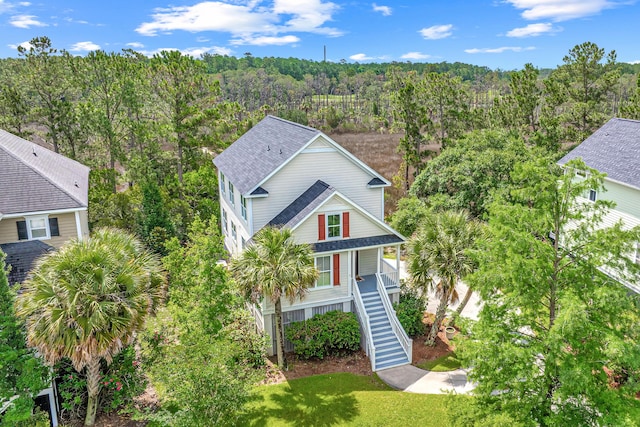 2301 N Creek Dr, Mount Pleasant, SC 29466 - view of front of home with stairway, a wooded view, covered porch, a shingled roof, and a front lawn