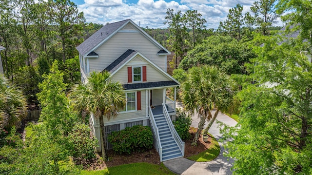 2301 N Creek Dr, Mount Pleasant, SC 29466 - raised beach house featuring stairway, covered porch, a shingled roof, and a view of trees