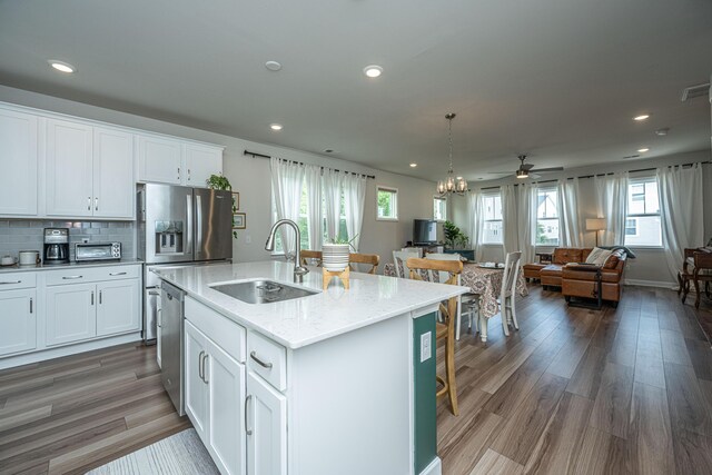 kitchen with hardwood / wood-style flooring, a center island with sink, white cabinetry, and sink