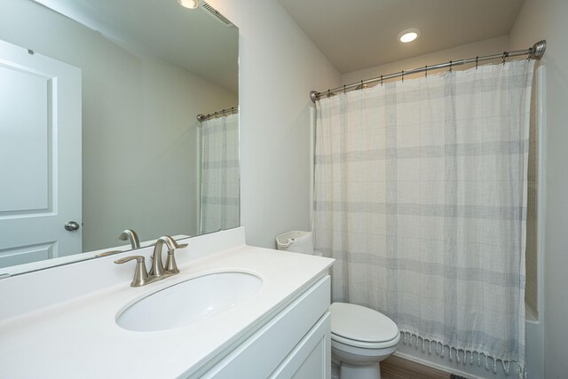 full bathroom with vanity, toilet, wood-type flooring, and shower / bath combo