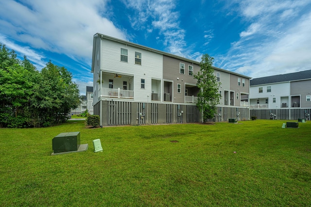 back of property featuring a residential view, a lawn, and a ceiling fan