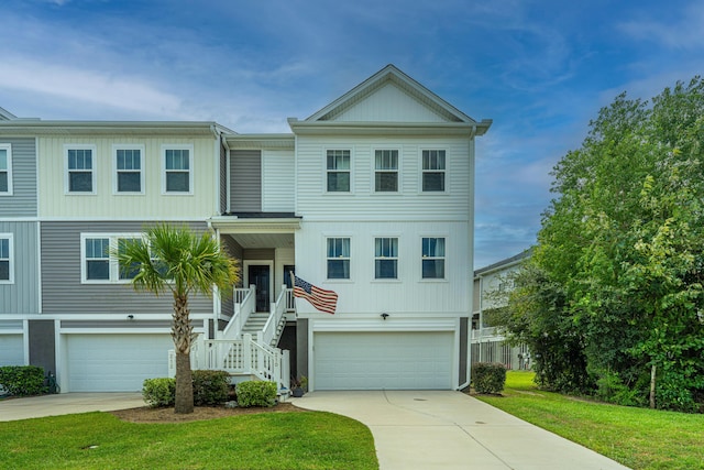 view of front of home featuring a front lawn, stairway, an attached garage, and driveway
