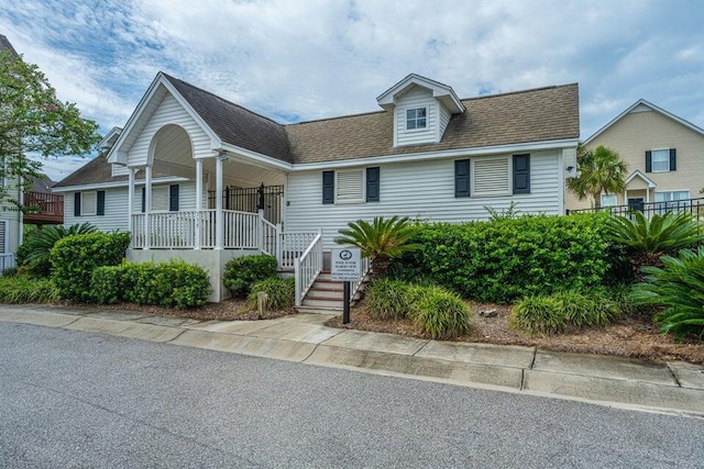 view of front of house with a porch and a shingled roof