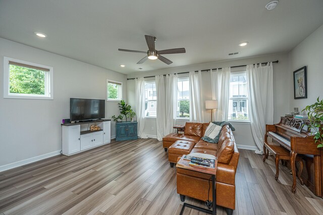 living room with light hardwood / wood-style flooring and ceiling fan