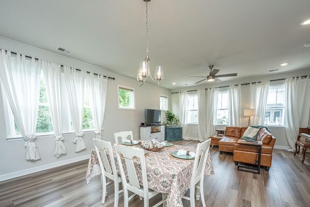 dining area featuring visible vents, ceiling fan with notable chandelier, recessed lighting, light wood-style floors, and baseboards