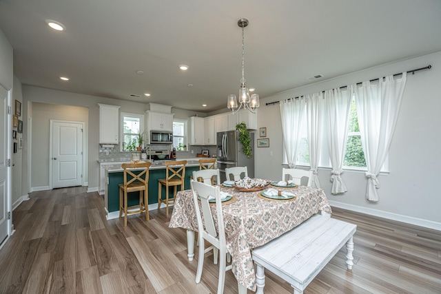 dining area with recessed lighting, light wood-style floors, baseboards, and a chandelier