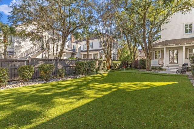 view of yard featuring entry steps, a fenced backyard, and a residential view