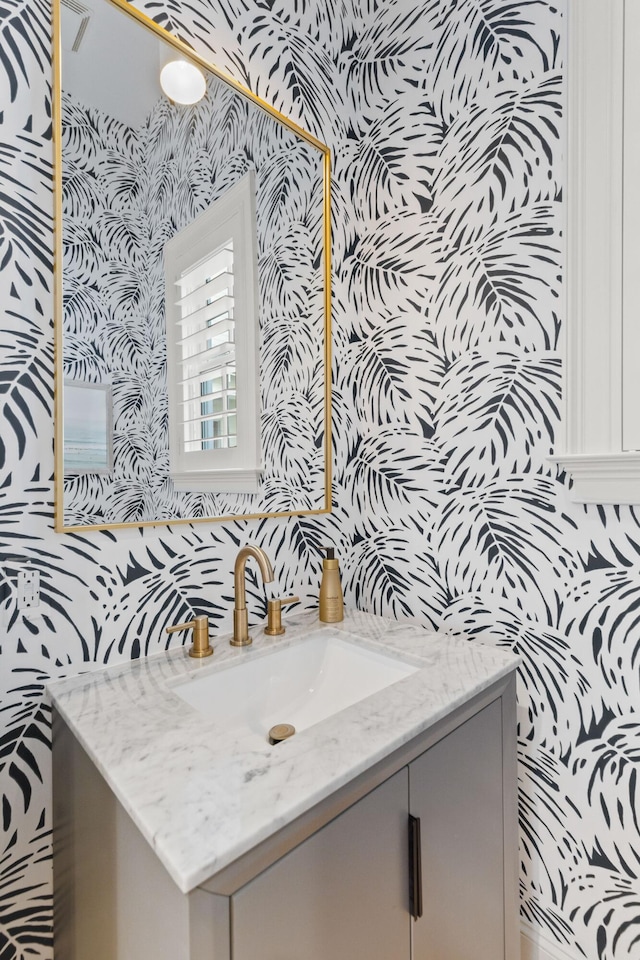 bathroom featuring vanity and wallpapered walls