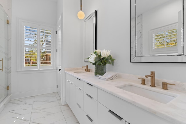 bathroom with double vanity, marble finish floor, baseboards, and a sink