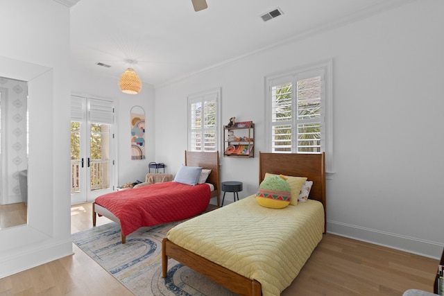 bedroom with light wood-style flooring, visible vents, baseboards, access to exterior, and crown molding