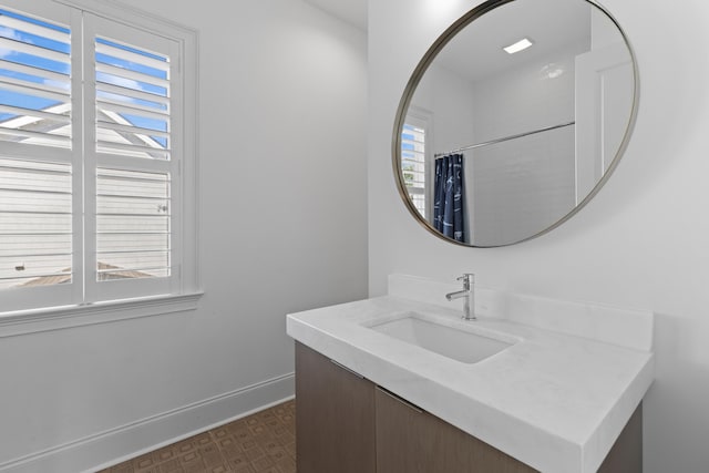 full bath with a shower with shower curtain, vanity, and baseboards