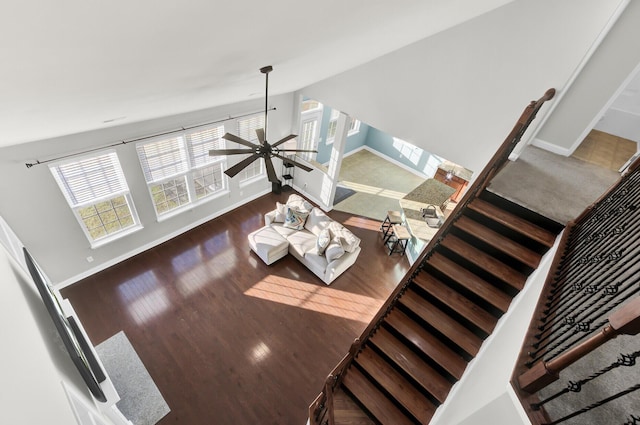 stairs featuring a ceiling fan, baseboards, and wood finished floors