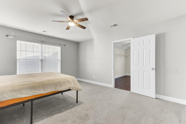 carpeted bedroom with visible vents, a ceiling fan, and baseboards