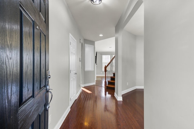 entryway with baseboards, recessed lighting, arched walkways, stairs, and wood-type flooring