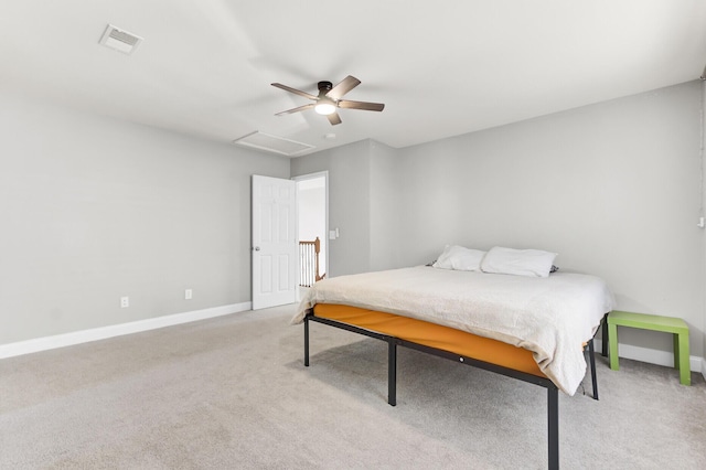 bedroom featuring visible vents, baseboards, light colored carpet, attic access, and a ceiling fan