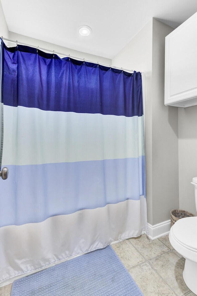 full bath with tile patterned flooring, toilet, baseboards, and a shower with curtain