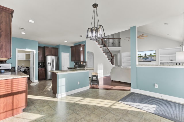 kitchen with dark brown cabinets, hanging light fixtures, stainless steel fridge, washer / clothes dryer, and a ceiling fan