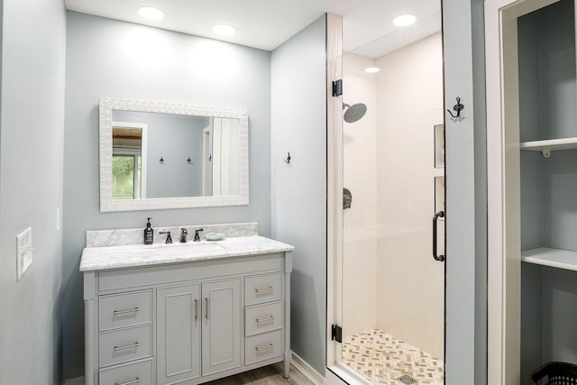 full bath with a stall shower, wood finished floors, vanity, and recessed lighting