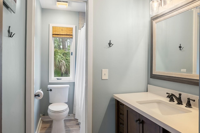 bathroom with wood finished floors, vanity, and toilet