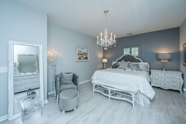 bedroom with light wood-type flooring and an inviting chandelier