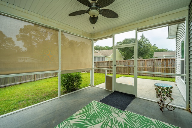 unfurnished sunroom featuring ceiling fan