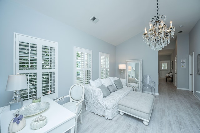 living room featuring a chandelier, light hardwood / wood-style floors, and vaulted ceiling