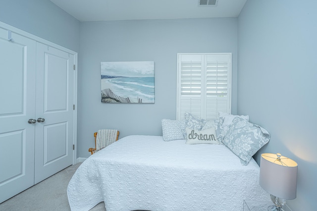 bedroom with light carpet and a closet