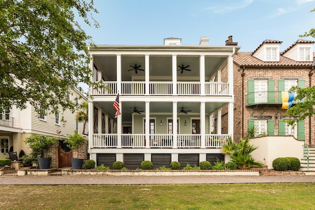 18 Fernandina St, Mount Pleasant, SC 29464 - view of front of house featuring a ceiling fan, brick siding, a balcony, and a front lawn