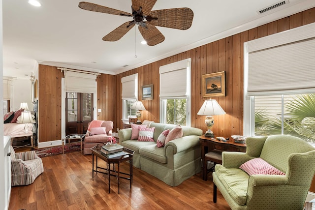 18 Fernandina St, Mount Pleasant, SC 29464 - living area featuring ceiling fan, wood finished floors, wood walls, and ornamental molding