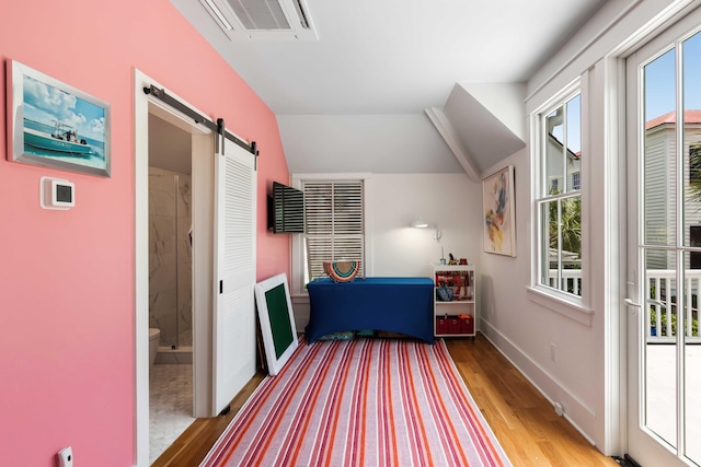 18 Fernandina St, Mount Pleasant, SC 29464 - bedroom featuring a barn door, light wood finished floors, baseboards, access to outside, and ensuite bath