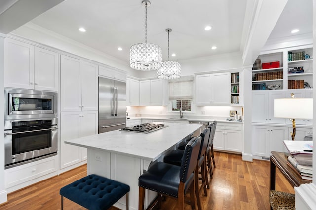 18 Fernandina St, Mount Pleasant, SC 29464 - kitchen with built in appliances, a sink, crown molding, a kitchen island, and white cabinets