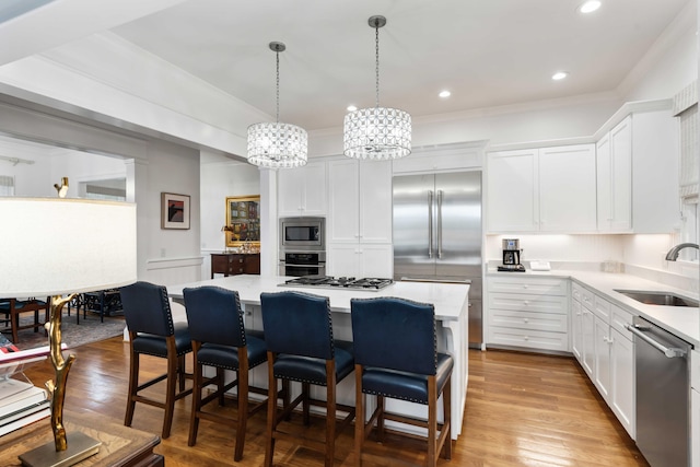 18 Fernandina St, Mount Pleasant, SC 29464 - kitchen with built in appliances, a sink, a center island, white cabinets, and crown molding