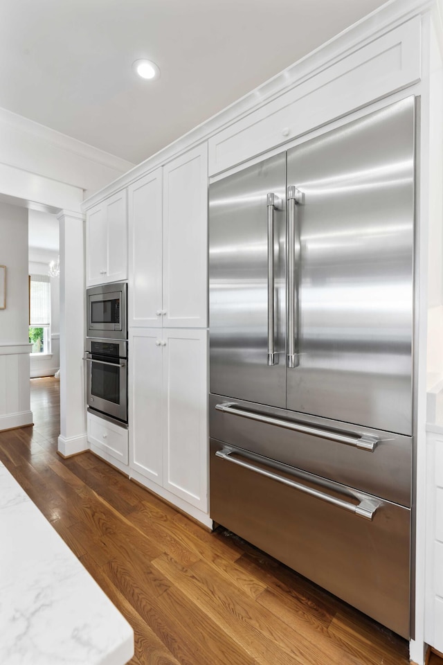 18 Fernandina St, Mount Pleasant, SC 29464 - kitchen with built in appliances, white cabinetry, dark wood finished floors, recessed lighting, and light stone countertops