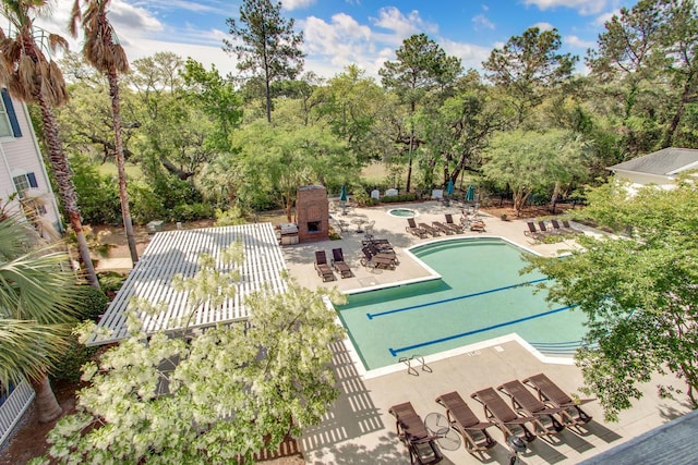 pool with exterior fireplace and a patio area