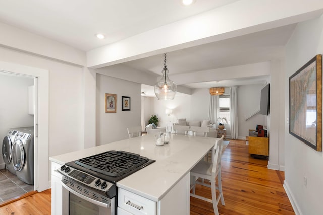 814 Rutledge Ave, Charleston, SC 29403 - kitchen featuring stainless steel gas range oven, separate washer and dryer, open floor plan, white cabinets, and light wood finished floors