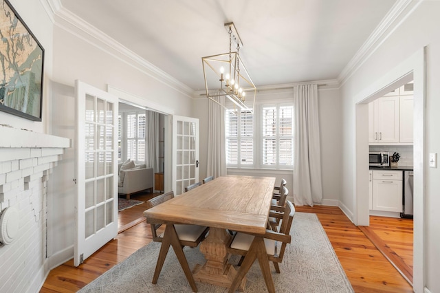 814 Rutledge Ave, Charleston, SC 29403 - dining room with french doors, crown molding, a chandelier, and light wood finished floors