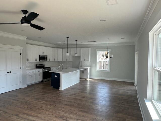 4126 Ohear Ave, North Charleston, SC 29406 - kitchen featuring stainless steel appliances, ornamental molding, white cabinets, tasteful backsplash, and an island with sink