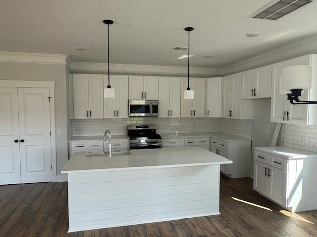 4126 Ohear Ave, North Charleston, SC 29406 - kitchen featuring stainless steel appliances, ornamental molding, a kitchen island with sink, tasteful backsplash, and white cabinets