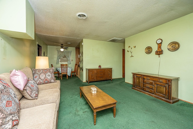 living room with visible vents, dark carpet, a textured ceiling, and ceiling fan