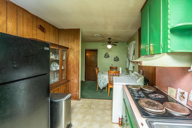 kitchen featuring brown cabinetry, ceiling fan, freestanding refrigerator, under cabinet range hood, and light floors