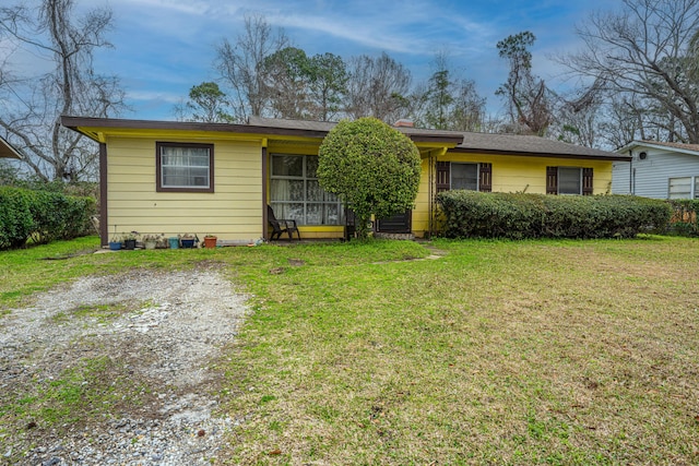 ranch-style house featuring driveway and a front lawn